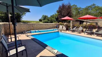 Relax by the pool surrounded by lush greenery and comfortable seating options.