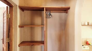 Un garde-manger d’angle avec des étagères en bois et un luminaire suspendu.