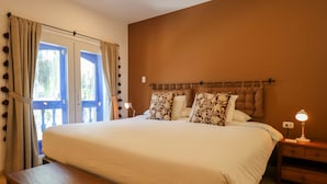 Ein Schlafzimmer mit einem großen Bett, einem Holzkopfteil, Nachttischlampen und einer Bank.
