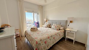 A bedroom with a bed, bedside tables, a chair, and a window with curtains.