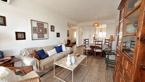 Un salon comprenant un canapé, une table basse et un coin repas avec des chaises et une table.