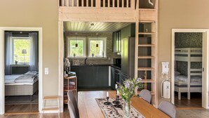 A loft-style bedroom with a bunk bed, a kitchen with a brick backsplash, and a dining area with a wooden table. - 2 bedroom amazing home in Säffle (Säffle)