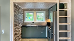 A compact kitchen with two windows, a built-in oven, and a wooden ceiling. - 2 bedroom amazing home in Säffle (Säffle)