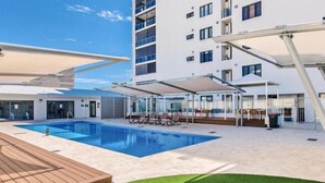 Un hôtel moderne doté d’une piscine, d’un espace extérieur aménagé et d’un patio couvert.