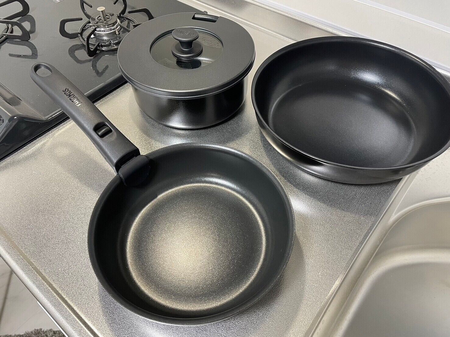Uma cozinha com fogão, frigideira e panela.