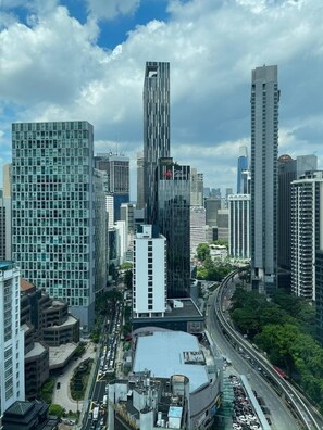 A cityscape with modern high-rise buildings, a curved road, and a large parking area. - Vortex Suites KLCC By BlackNest (Kuala Lumpur)