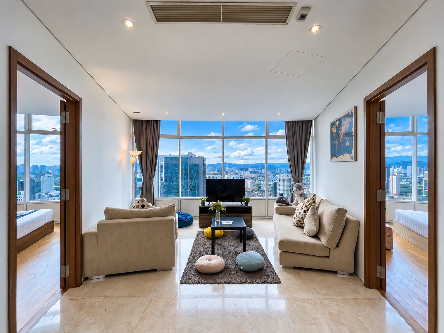 A modern living room with a city view, furnished with sofas and a coffee table.