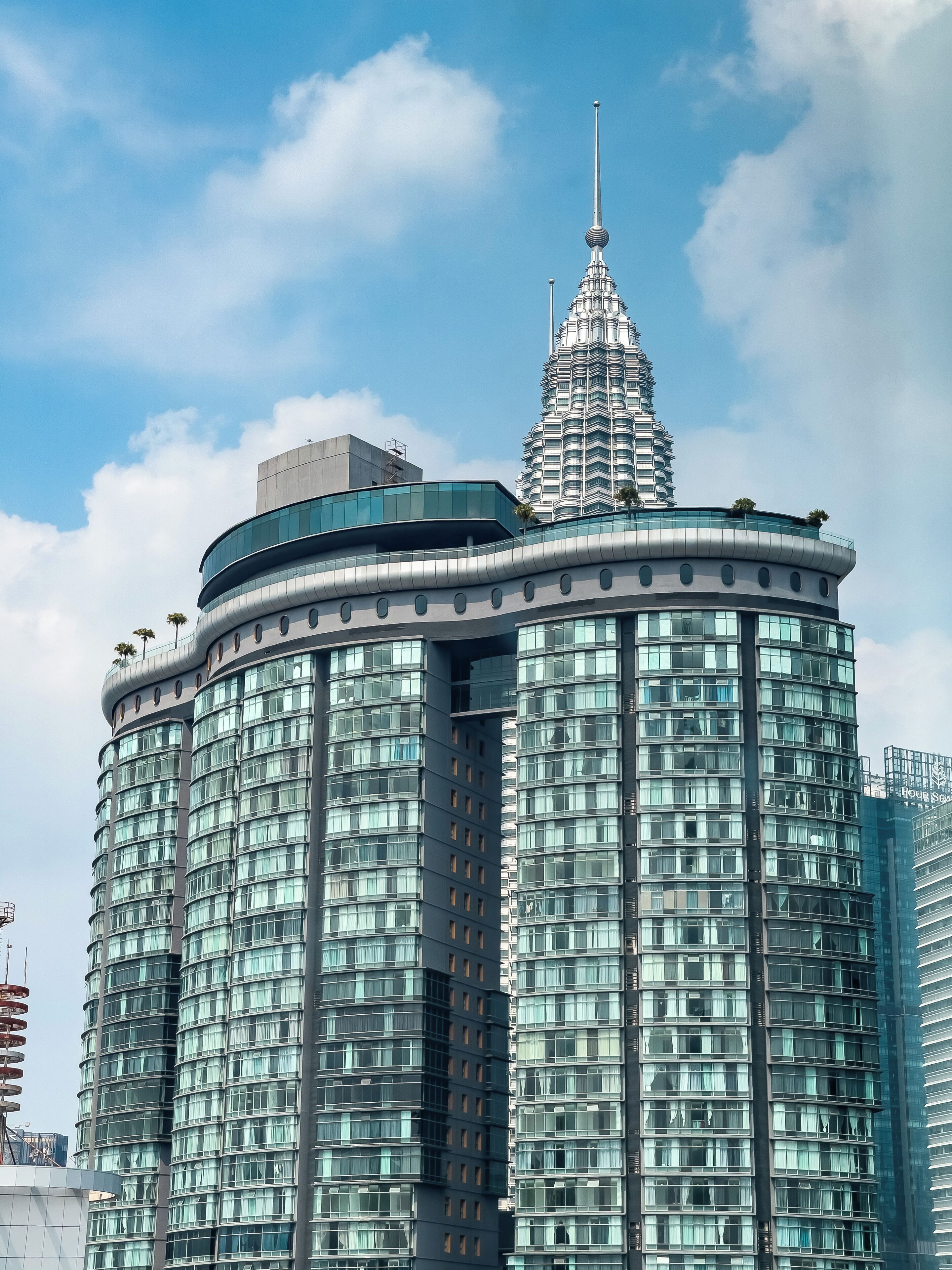 A modern high-rise building with a distinctive spire and curved facade.