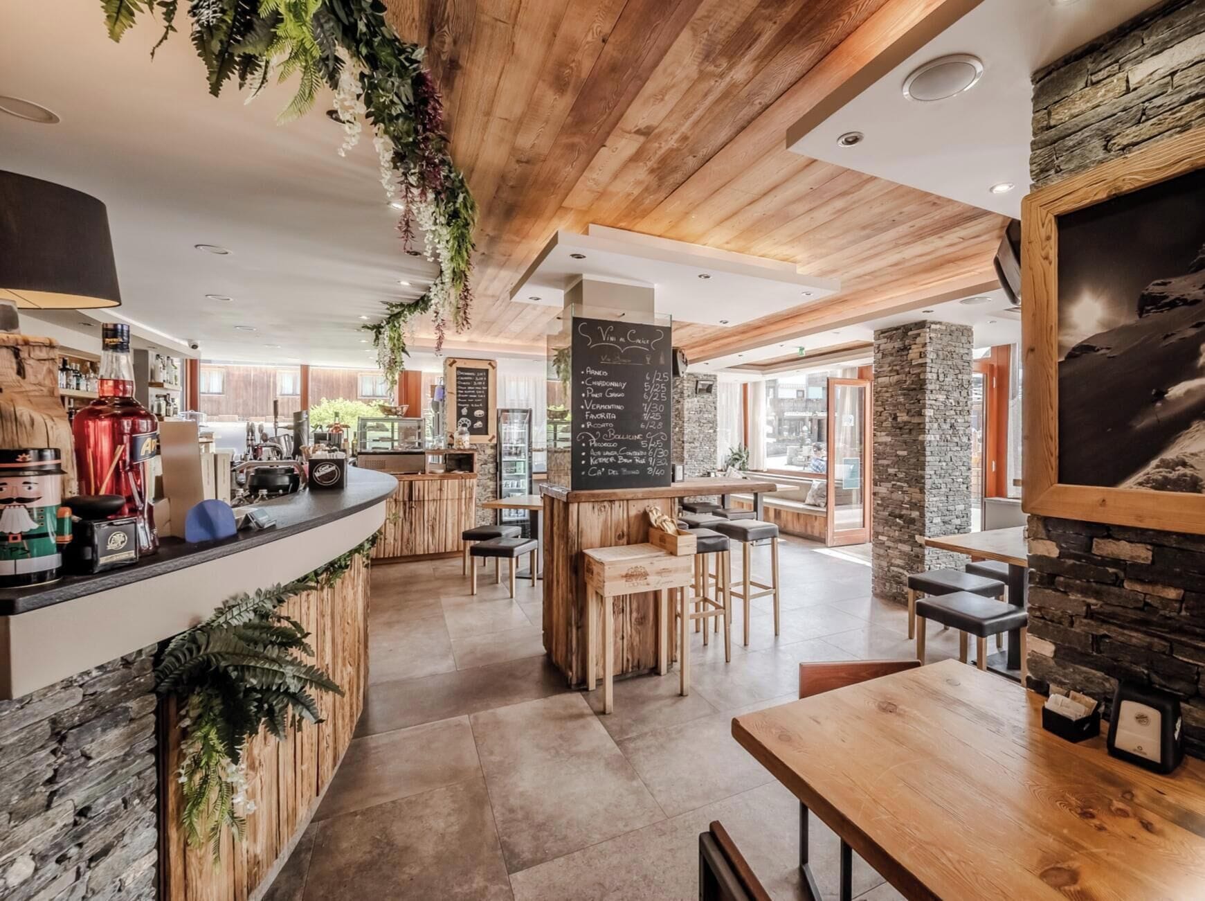 A cafe with a wooden interior, a chalkboard menu, and a stone wall.