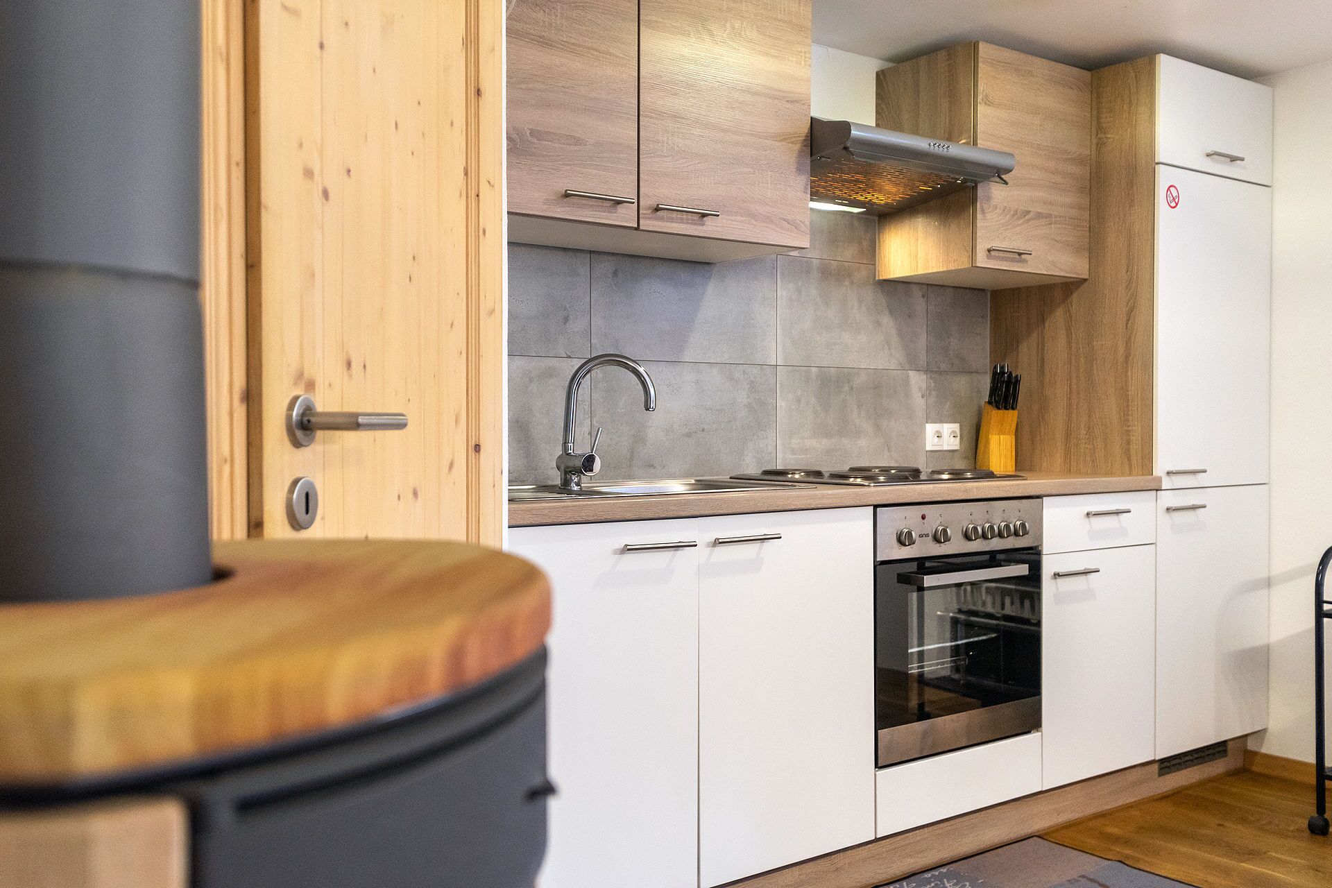 Une cuisine moderne avec des armoires blanches, des appareils en acier inoxydable et un plan de travail en bois.