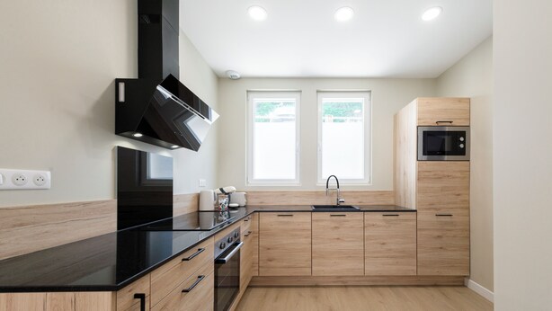 A modern kitchen with wooden cabinets, a black countertop, a built-in oven, and a microwave. - F3 au Coeur des Cordiers, Avec Parking Privatif Inclus (Le Tréport)