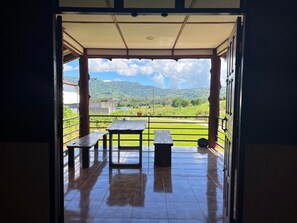 Eine Terrasse im Freien mit gefliestem Boden und zwei Picknicktischen.