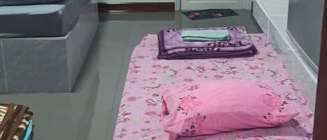Una habitación con cama, una mesita, un televisor y un equipo de aire acondicionado.