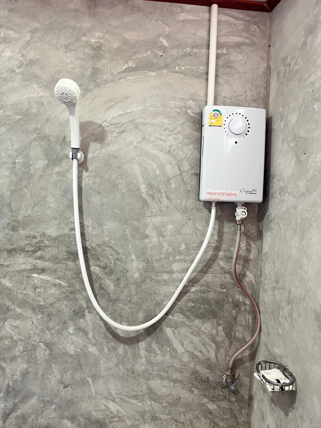 A shower with a handheld showerhead and a control unit mounted on the wall.