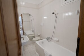 A bathroom with a sink, toilet, and bathtub.