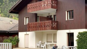 A two-story building with a balcony featuring decorative metal railings. - Cozy studio with parking, pets allowed (Samoëns)