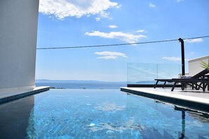 A clear blue sky with a view of the sea and distant mountains.
