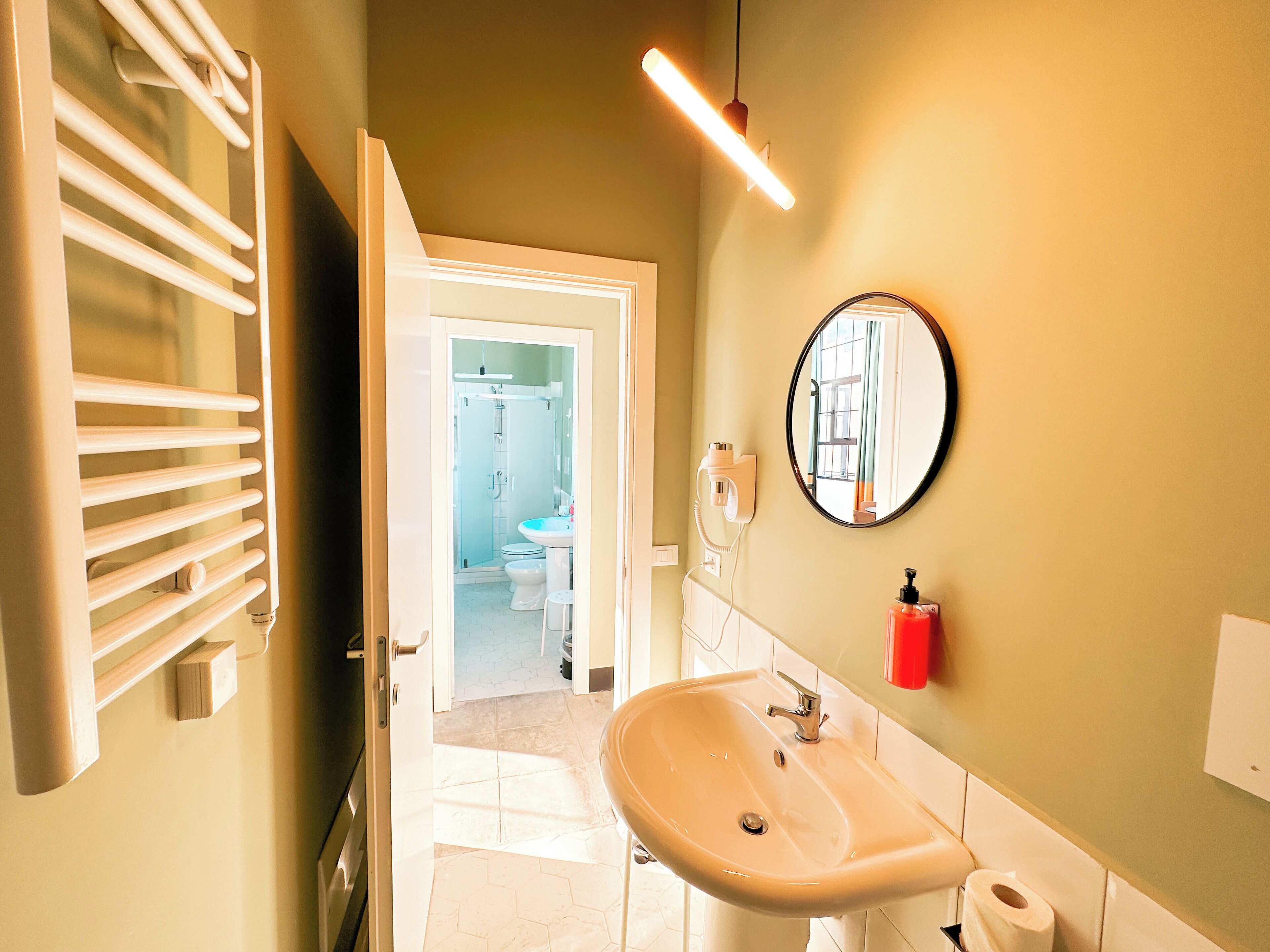 A bathroom with a sink, mirror, and towel rack.
