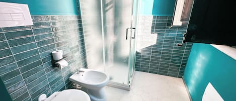 Ett badrum med toalett, bidé och duschutrymme.