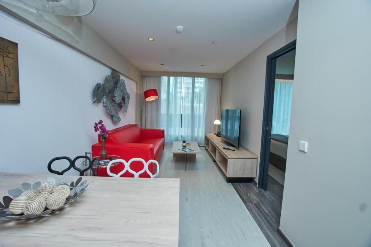 Un salon moderne avec un canapé rouge, une table basse et un téléviseur.