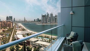 A balcony with a view of a city skyline, a beach, and a marina.