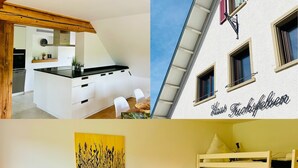 Une cuisine moderne avec des meubles blancs et un plan de travail noir, une chambre confortable avec un lit et une table de chevet, et la façade d’un immeuble sur laquelle on peut lire l’inscription « Hôtel Tuchfeuer ».