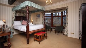 A four-poster bed with a canopy, a desk with a chair, and a view of the outside through a window. - The Olde Ship Inn (Seahouses)