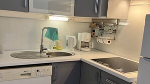 A modern kitchen with a Bosch dishwasher, a coffee maker, and a sink.