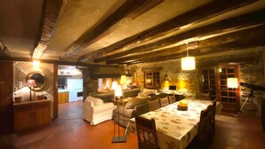 A rustic dining area with exposed wooden beams, a round mirror, and a table set for dining. - Chalet 12 Personne - Seul au Monde (Vars)