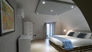A bedroom with a loft-style ceiling, a bed with a wooden platform, a desk, and a chair. - Antique dwelling, strategically located for Naples, Sorrento, Pompeii, Positano. (Portici)