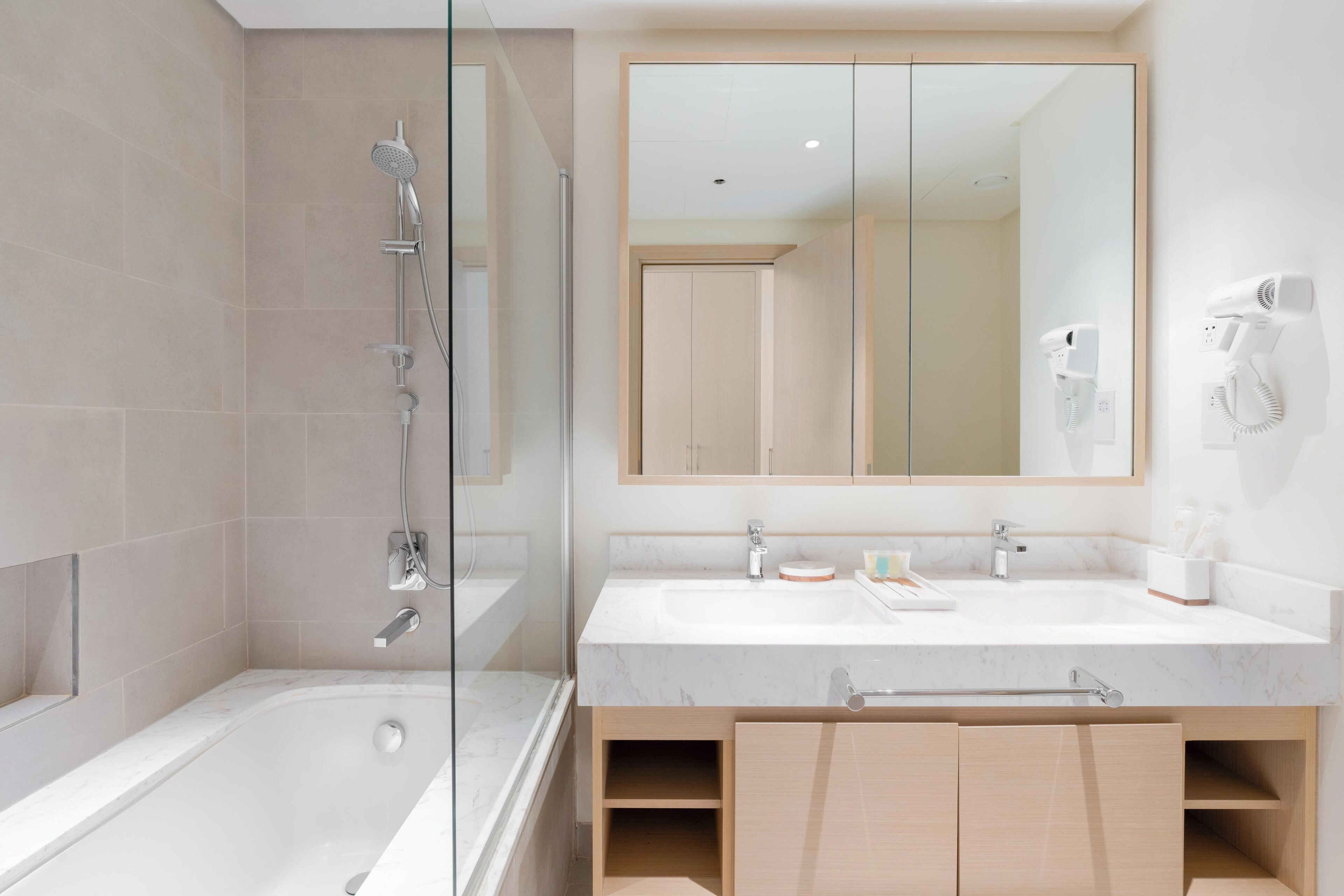 Un bagno moderno con doccia vetrata, uno specchio grande e un mobile lavabo con lavandino e portasciugamani.