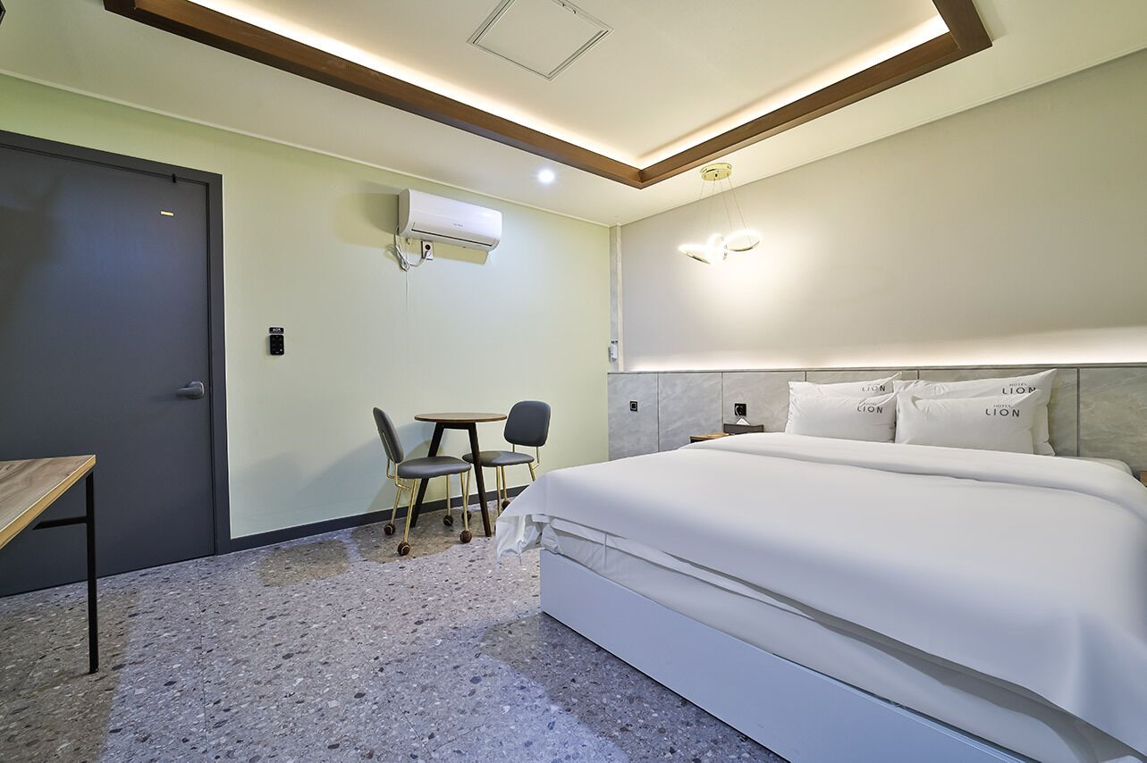 A hotel room with a bed, a desk, and two chairs.