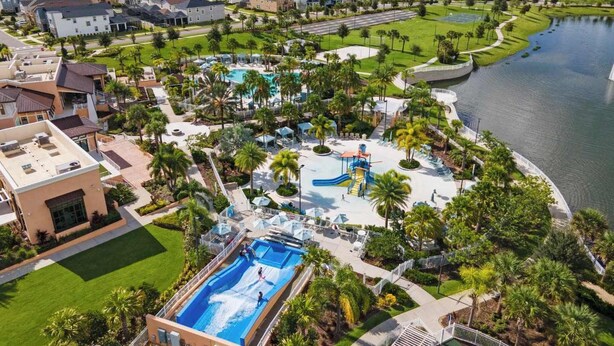 A residential area with a large swimming pool, water slides, and a lake. - Kissimmee Villa: 9BR Oasis, Sleeps 16 (Kissimmee)