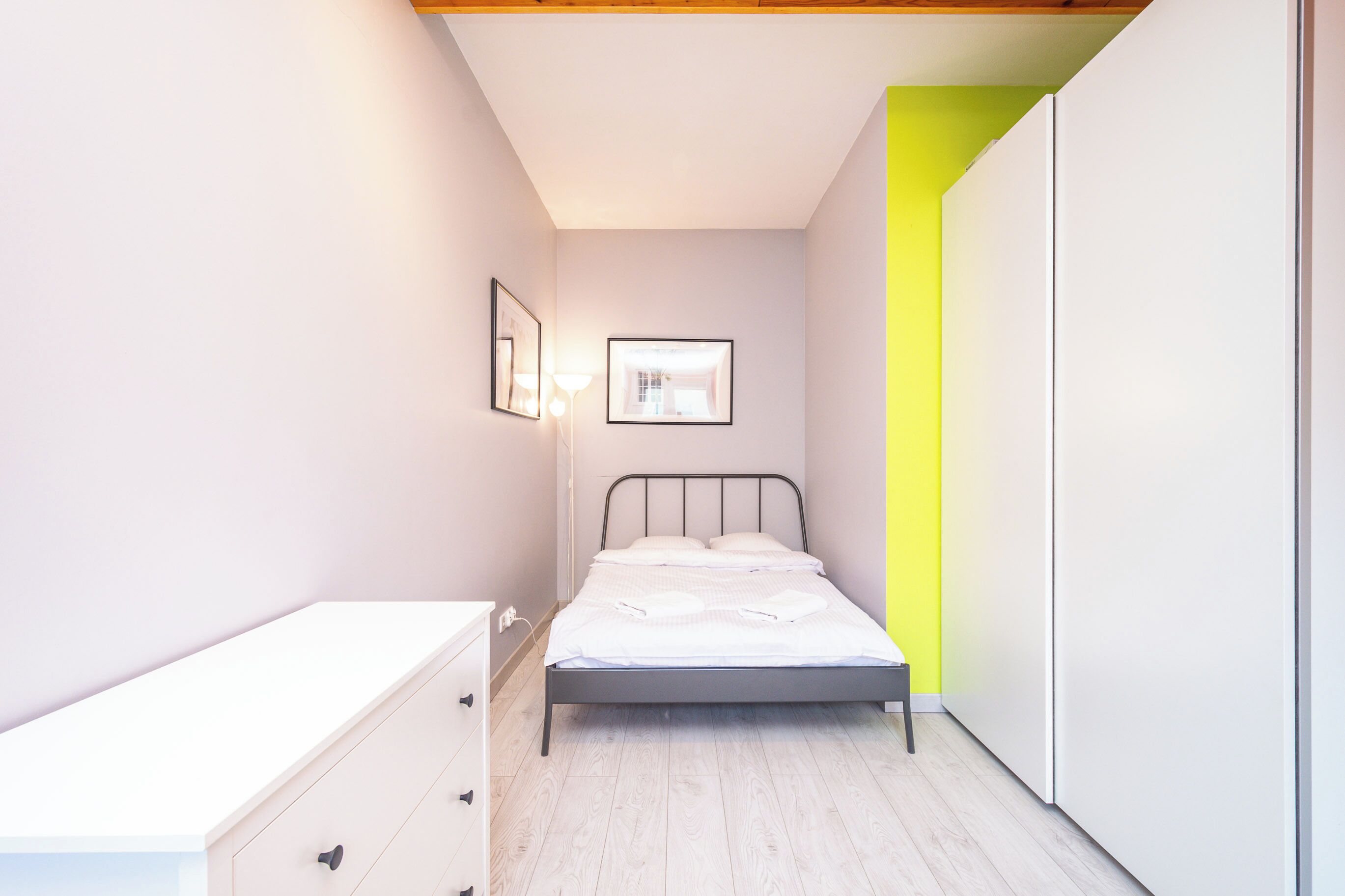 A bedroom with a bed, a dresser, and a wardrobe.