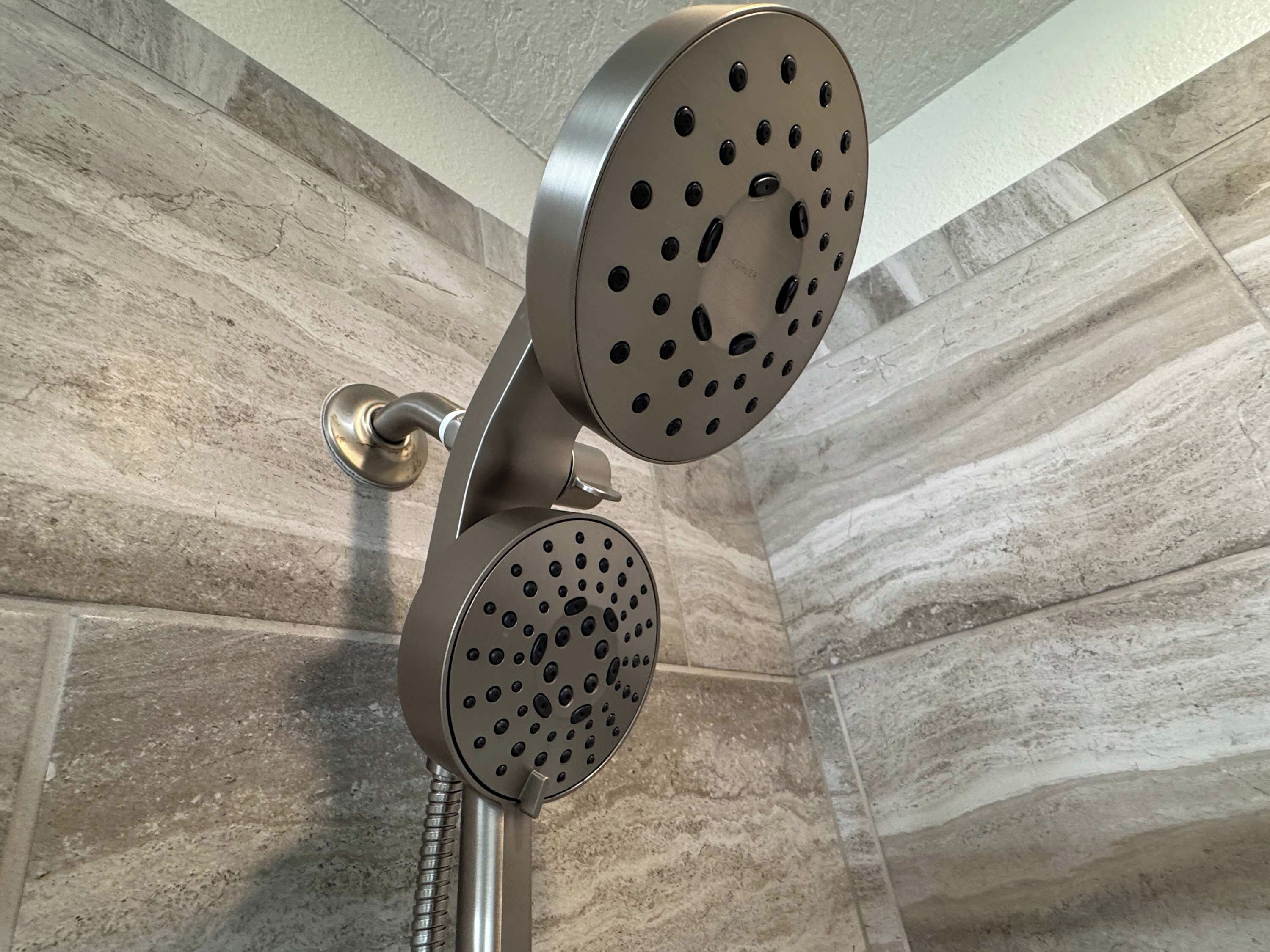 A shower with a curved design and multiple nozzles.
