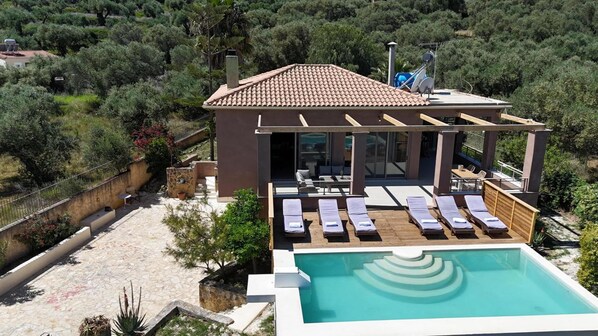 A modern villa with a rooftop pool, outdoor seating, and a view of the surrounding greenery. - Astarte Villas - Stilvi 4 Bedroom Private Villa With Pool (RV3V+9Q3 Zakynthos, Greece)