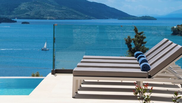 A poolside lounge with a view of a clear blue sea and distant mountains. - Brand new Spacious 6 bedroom villa with stunning view, close to beach. (Lefkada)