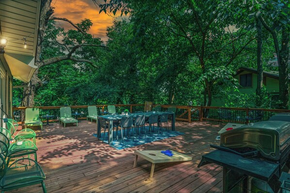 A wooden deck with outdoor furniture, a grill, and a table. - Great for Bachelor/ette parties and Family Gatherings! (Lake Ozark)