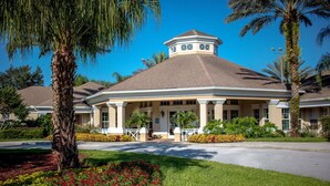 A hotel with a central rotunda, palm trees, and a well-maintained lawn.