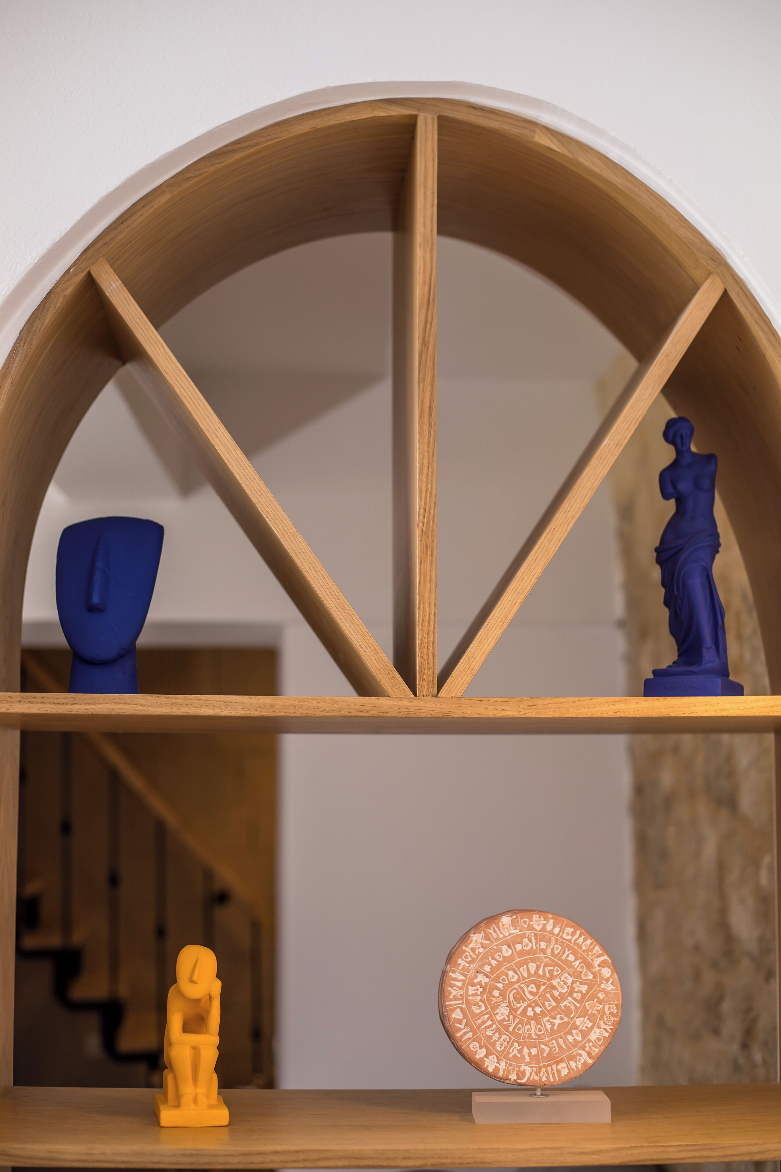Ein Holzboden mit einer blauen Vase, einer Statue und einer runden Plakette.