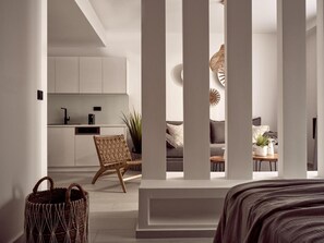 Un intérieur moderne comprenant une cuisine, un coin salon et un lit.