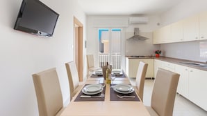 A modern kitchen with white cabinets, a built-in stove, and a flat-screen TV mounted on the wall. - 3952 Trilo di Annahouse by Barbarhouse (Porto Cesareo)
