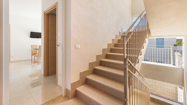 A modern interior with a staircase, a dining area, and a flat-screen TV. - 3952 Trilo di Annahouse by Barbarhouse (Porto Cesareo)
