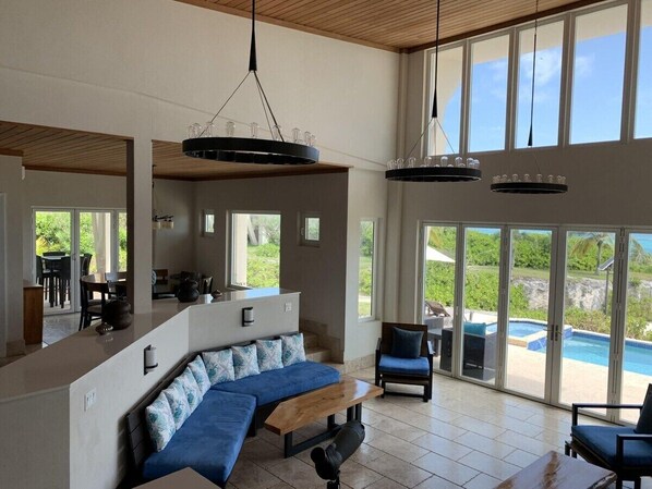 A spacious living area with a large sectional sofa, a dining table, and a kitchen area.
