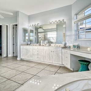 A spacious bathroom with a large vanity, double sinks, and a ceiling fan. - Boaters Dream S Terr Pool Yacht Club Boating (Cape Coral)