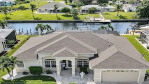 A large, single-story house with a covered patio, a garage, and a swimming pool. - Timeout -south Facing With Large Terrace and Pool (Cape Coral)