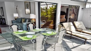 A patio with a glass table and metal chairs, a sofa, and a lounge area with chairs. - Belle Paradise - 3 3 Pool Boating Oasis of Calm (Cape Coral)