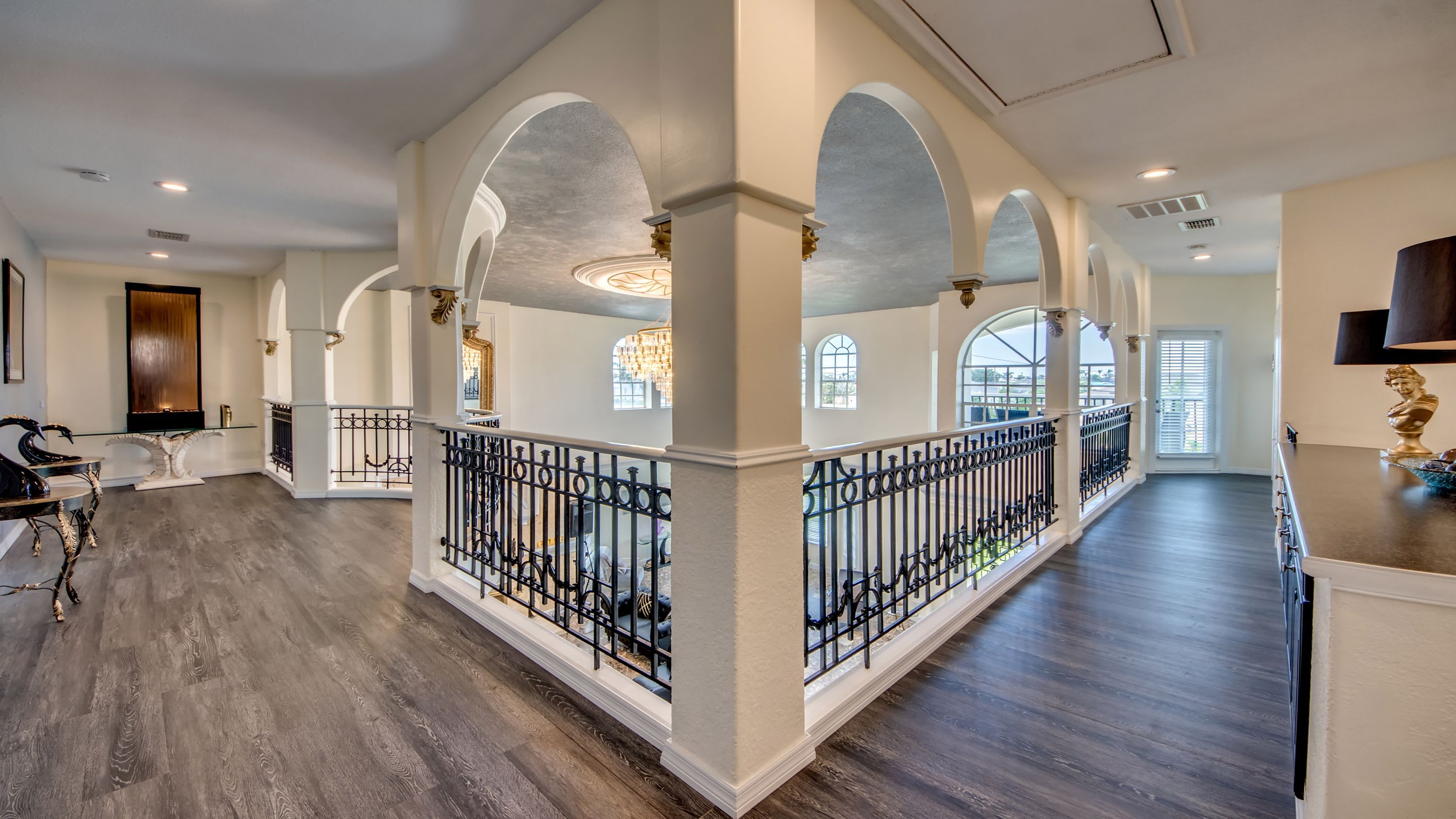 Un intérieur spacieux avec de hauts plafonds, des colonnes en arc de cercle et un magnifique escalier.