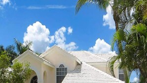 A two-story house with a white exterior, a garage, and a well-maintained lawn. - Altaira - top Location Lake View Pool Spa 4 Bed (Naples)