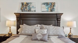 A neatly made bed with patterned pillows and a dark wooden headboard. - Cozy vintage home in the heart of Riverside one block from golf, and much more (Wichita)